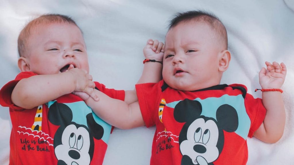 twin babies wearing mickey mouse pajamas